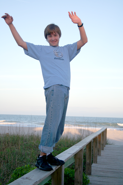 Joey balancing on boardwalk fence railing at the beach